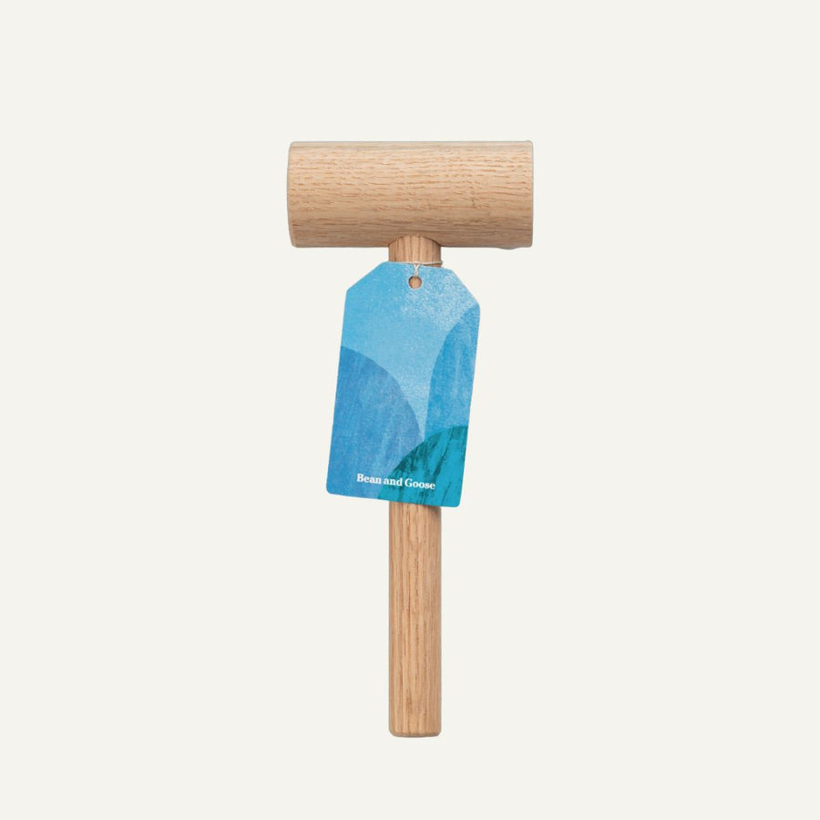 Wooden mallet with a blue tag on a white background