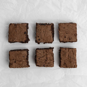 Six chocolate brownies arranged on parchment