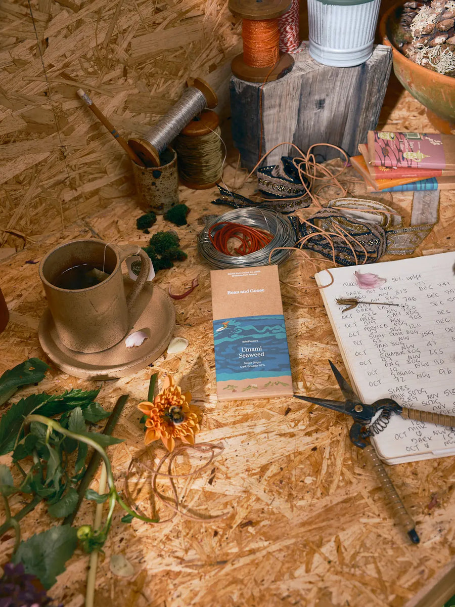 A cup of Bean and Goose hot chocolate on a potting table