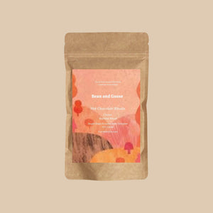 Kraft paper packaging of 'Bean and Goose' hot chocolate with a colorful label on a beige background