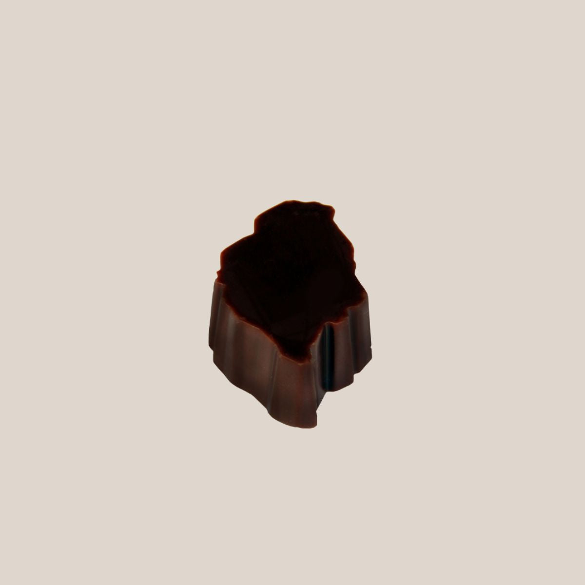 Single dark chocolate island piece from Bean and Goose Advent Calendar on cream background