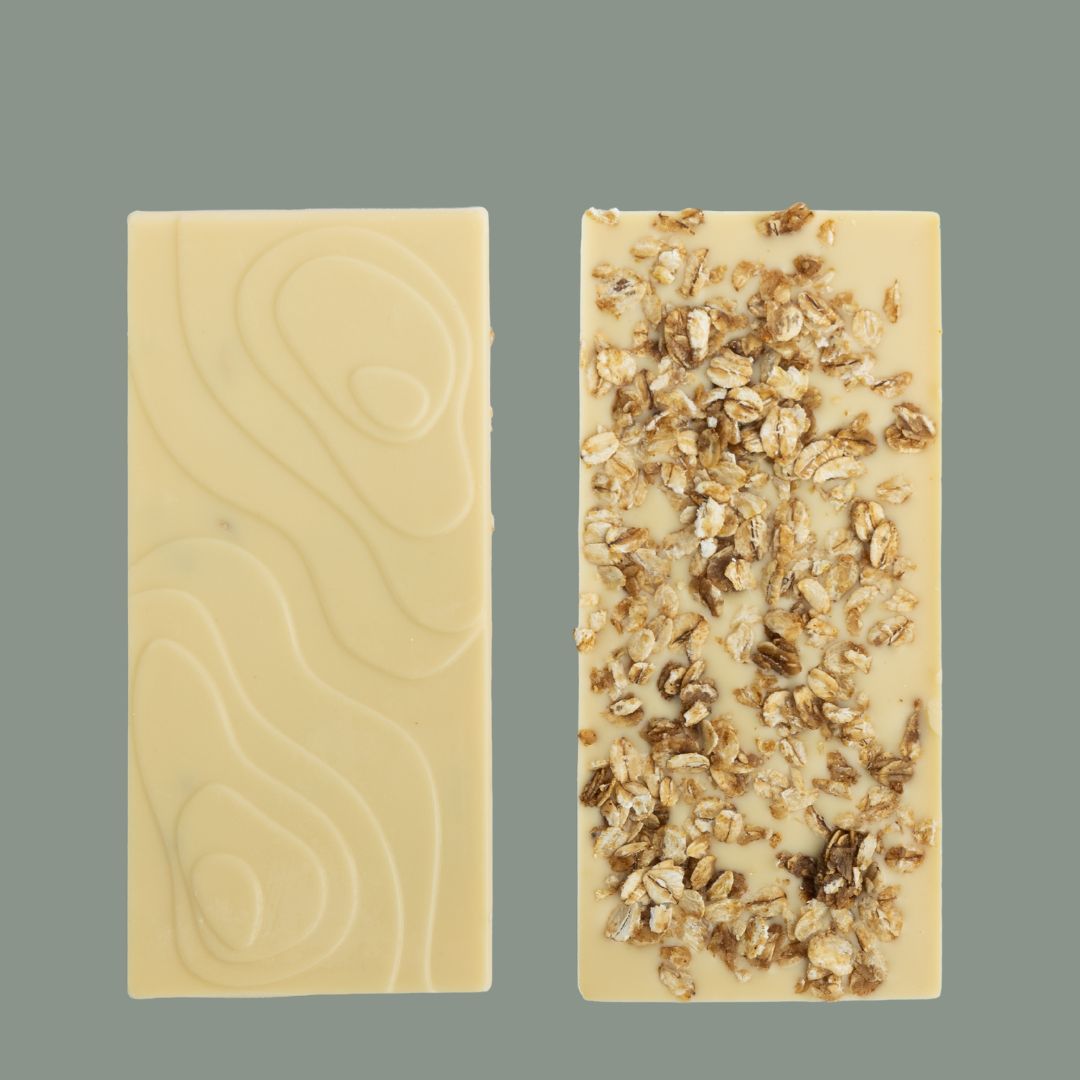 Both sides of Bean and Goose Fireside Glow White Chocolate Bar on Grey Background