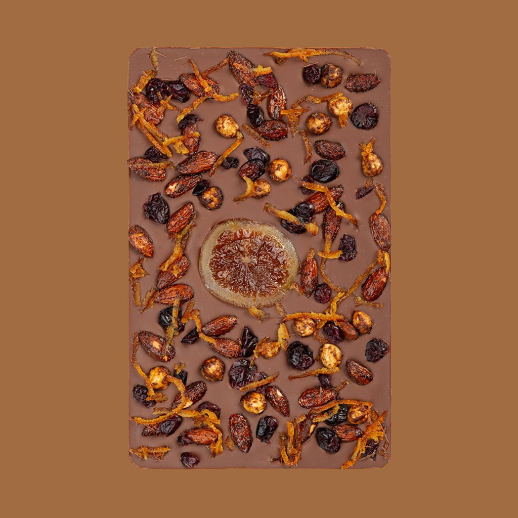 Chocolate bar with dried fruits and nuts on a brown background