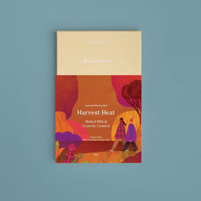 Bean and Goose Chocolate Beige and colorful packaging of 'Harvest Heat' Sharing Slab on a blue background