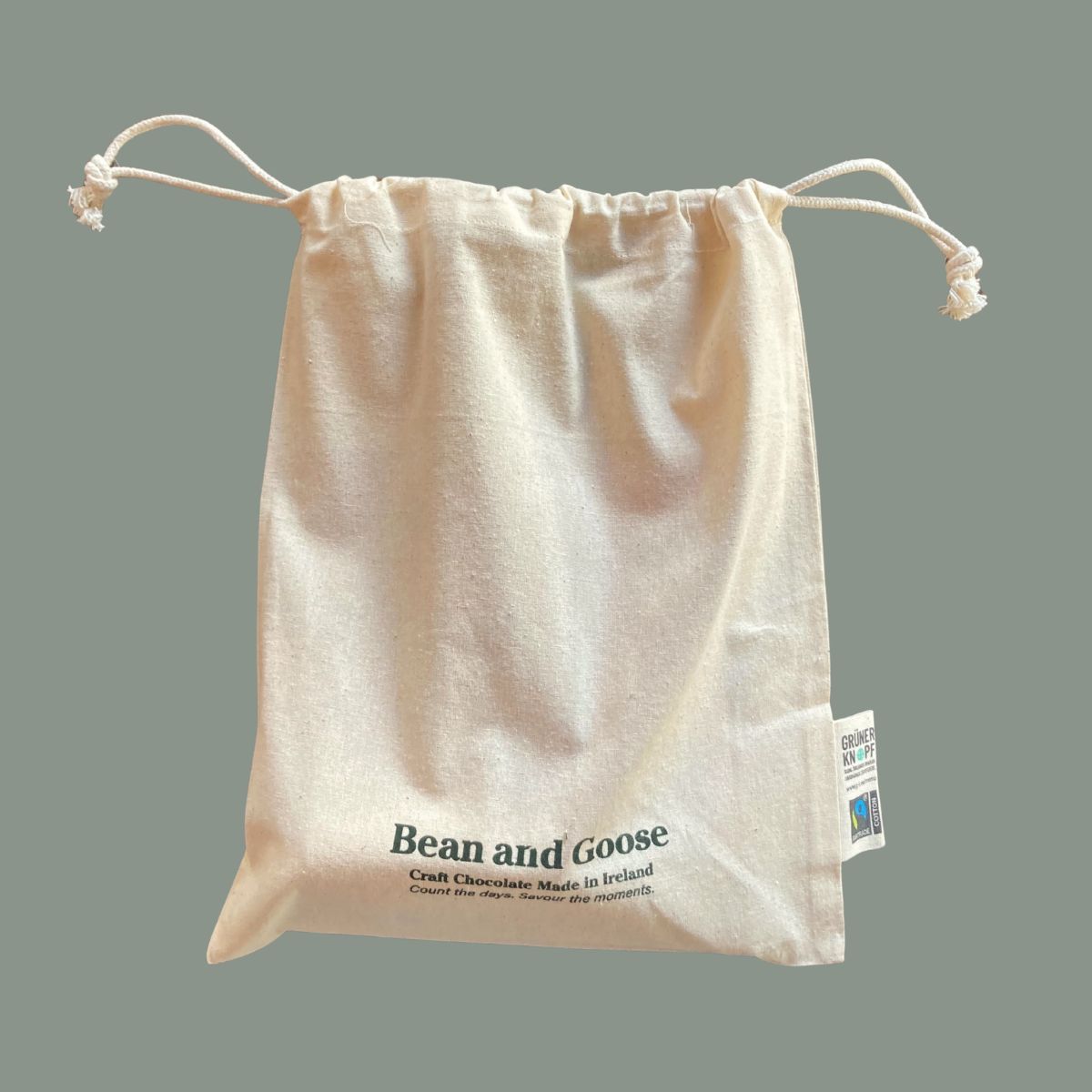 Beige drawstring bag with 'Bean and Goose' branding on a gray background
