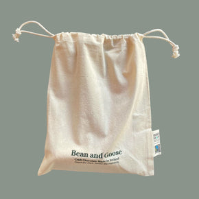Beige drawstring bag with 'Bean and Goose' branding on a gray background