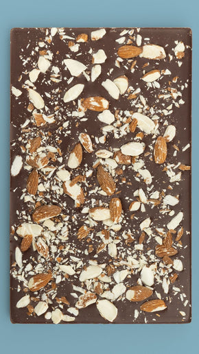Bean and Goose Smoke & Stone Sharing Slab topped with almonds on a blue background
