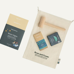 Bean and Goose chocolate packaging with a wooden hammer on a beige cloth background